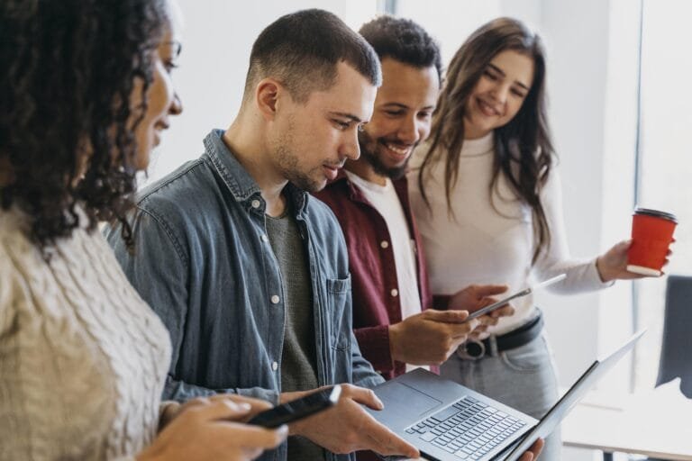 Profissionais utilizando Serviços de marketing e Tráfego Pago com dispositivos móveis, incluindo notebook, celular e tablet, para impulsionar negócios e alcançar sucesso online.